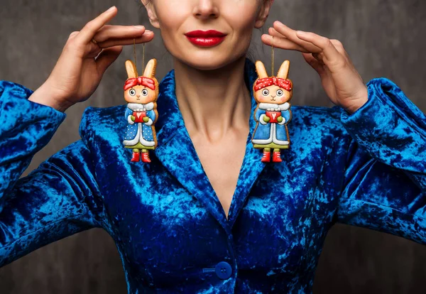 クリスマスウサギ手作りおもちゃ ブルースーツの女性は バニージンジャーブレッドハンギングでドレス 焼き生姜クッキー漫画ヴィンテージスタイル 女性魔術師とともに赤い唇以上グレーの背景 — ストック写真