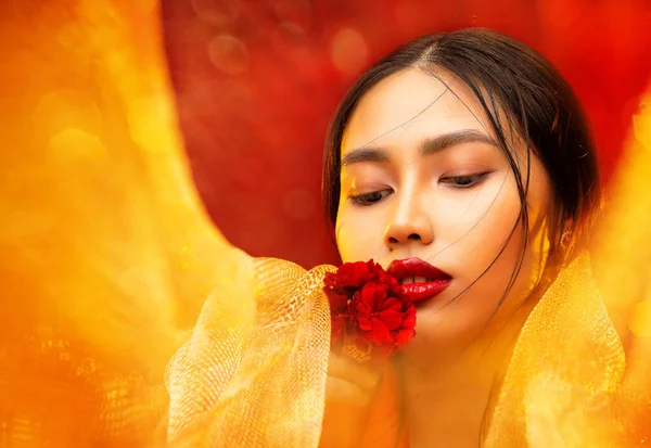 亚洲美丽的吉尔肖像 红唇飘香的花朵 中国妇女与光滑的皮肤化妆 美丽的日本模特 背景为金色面料 — 图库照片