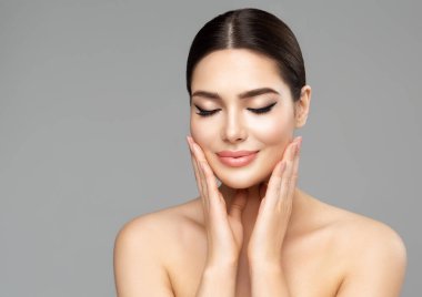 Güzellik Yüzü Bakımı. Tamamen Dudaklı Kadın Doğal Makyajlı Tecrit edilmiş bir arka plan. Güzel Model Spa Masajı 'nın tadını çıkarıyor. Yüz Estetik Cerrahisi ve Cilt Doldurucu Kozmetoloji