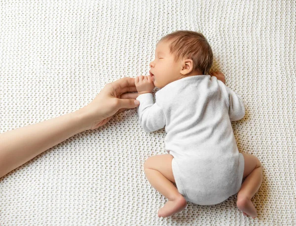 母親の手を握っている赤ん坊 眠っている新生児の胃の上に横たわっ 白い毛布の上でOnesie睡眠中の美しい乳児 小さな子供の健康管理と開発 — ストック写真
