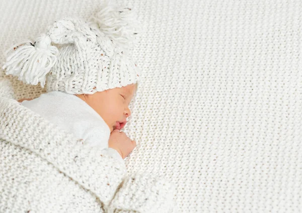 Малыш Шерстяной Шляпе Помпоном Спит Вязаном Белом Одеяле Новорожденный Лежит — стоковое фото