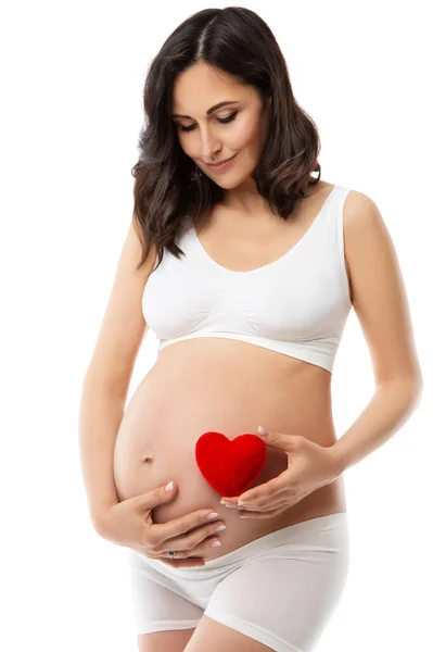 快乐怀孕的女人带着红心在美女身上 妊娠期健康体皮肤护理 美丽的未来之母穿着白色棉衣 产妇保健和美容 — 图库照片