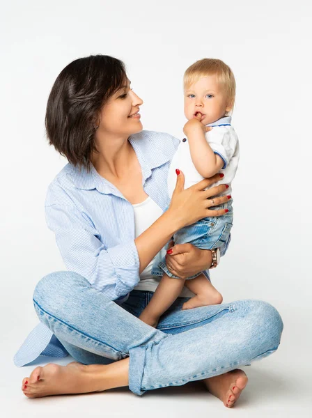 幸せな母親の赤ちゃんを見て指を吸う 白い孤立した上に笑顔のママと幼児の男の子 小さな子供の健康管理と開発 1年の息子を持つママ — ストック写真