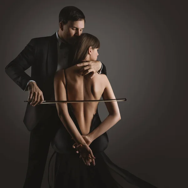 性感情侣之吻 音乐人 小提琴鞠躬演奏大提琴女人的身体 古典音乐爱情歌手在黑人之上表演 艺术照片 图库图片
