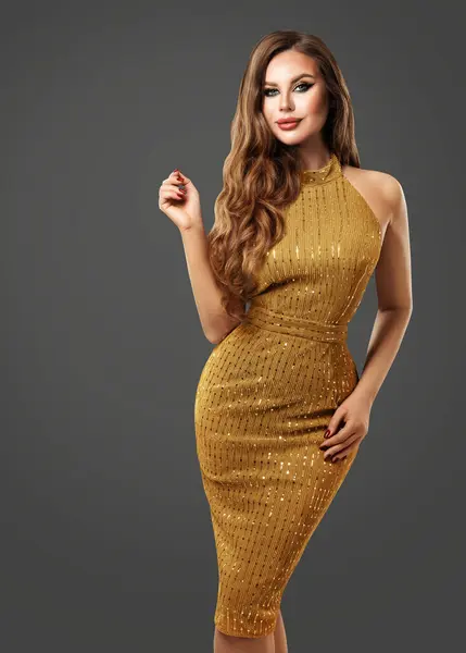 Beautiful Fashion Woman in Golden Dress. Sexy Girl in Gold Glitter Gown. Elegant Lady in Luxury Dress over dark Gray