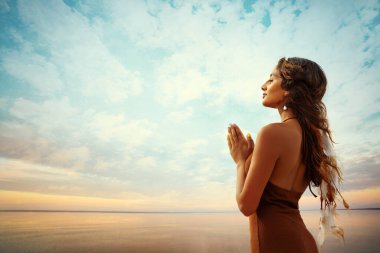 Günbatımı Deniz manzarası üzerinde dua eden kadın silueti. Namaste Hands ile Hint Kız meditasyonu. Yoganın keyfini çıkaran mutlu kadın. Minnettar Umut Kadını