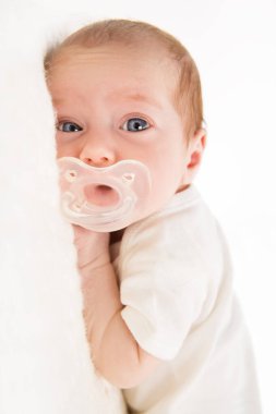 Sakin Bebek, Kameraya bakarak emzirici. Çocuklu çocuk daha pürüzsüz. Bebek Kız Yüzlü Portre Taklit ve Mavi Büyük Gözler Beyaz Yatak Odasında Midenin üzerine uzanmış