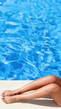 Havuz kenarında güneşlenen kadın bacakları.