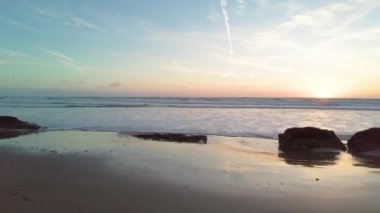 Gün batımında sahilde gelgit var.