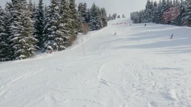 Kayakçı kayak sporcusu dağlık yamaçta kayak yapıyor. Kayak yaparken. Yüksek hız. Tanınmayan insanlar. Karakol Kayak Merkezi. Kırgızistan 'ı ziyaret eden turistler için popüler tatil beldesi.