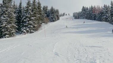 Kayakçı kayak sporcusu dağlık yamaçta kayak yapıyor. Kayak yaparken. Yüksek hız. Tanınmayan insanlar. Karakol Kayak Merkezi. Kırgızistan 'ı ziyaret eden turistler için popüler tatil beldesi.