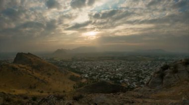 Osh şehrinin üzerindeki bulutların zamanı. Gün batımında ufuk çizgisi panoramik manzarası küçük şehrin çatıları üzerinde, altın saat saatinde. Sulaiman 'dan Osh şehrinin manzarası Çok dağ, Kırgızistan. 