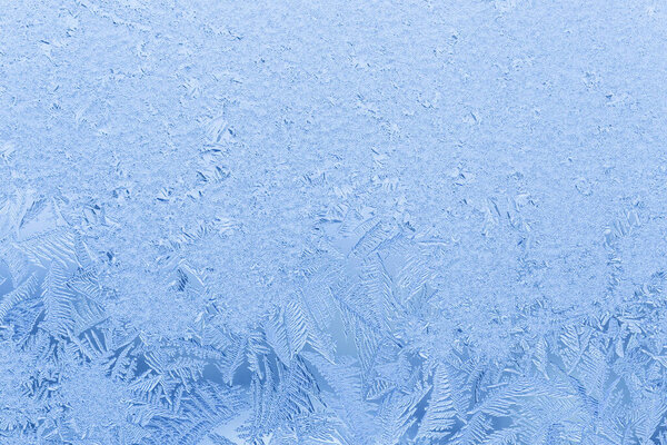 close up of blue frost pattern on frozen window