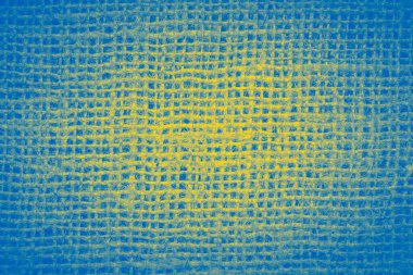 abstract rustic background: close up of burlap texture colored in colors of Ukrainian fla