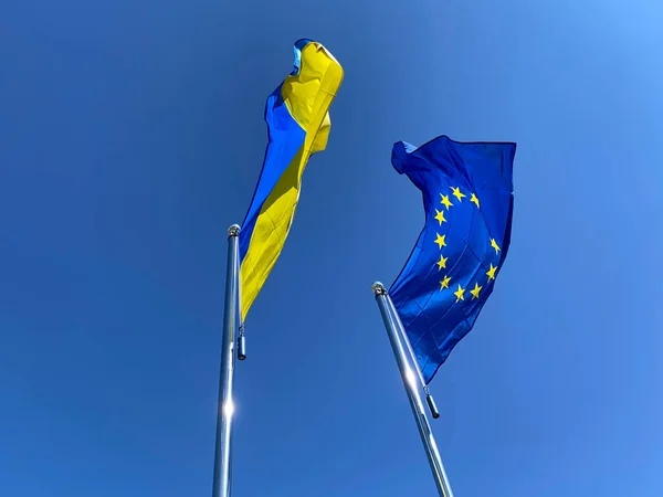Vlaggen Van Oekraïne Europese Unie Wapperden Vlaggenmasten Tegen Blauwe Lucht — Stockfoto