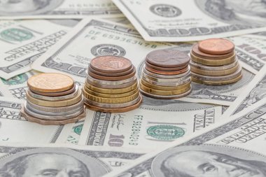 100 Amerikan dolarının üzerinde duran bir yığın farklı ülke sikkeleri