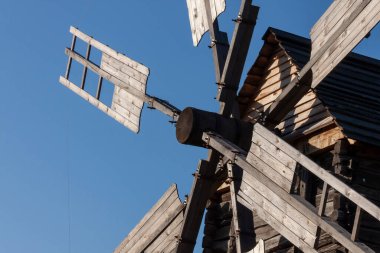 Mavi gökyüzüne karşı eski Ukrayna ahşap yel değirmeninin yakınında