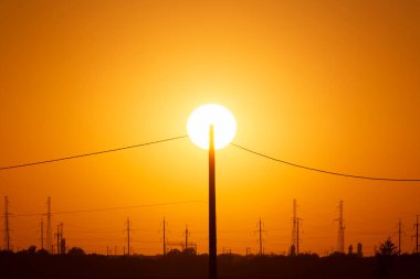 Güneş batarken elektrik direğine karşı görüş