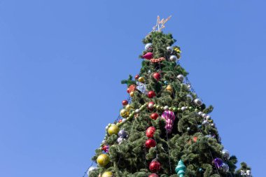 Mavi gökyüzüne karşı suni Noel ağacının tepesi