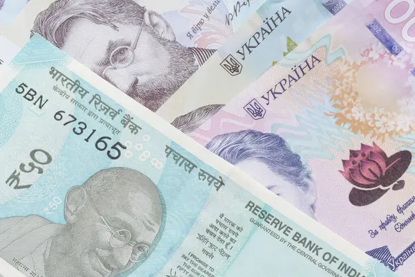 Крупным Планом Пятидесяти Индийских Рупий Лежащих Украинских Гривне Банкнотах — стоковое фото