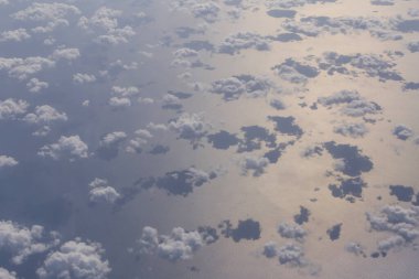 Bulutların üzerindeki hava manzarası ve deniz yüzeyindeki gölgeleri.