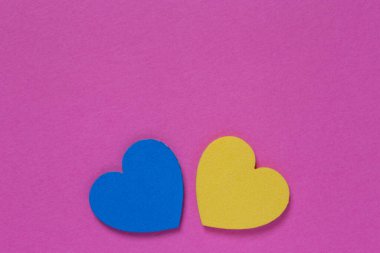 Ukrayna arka planı ile ayakta durun: Pembe renkli karton üzerinde mavi ve sarı kalpler