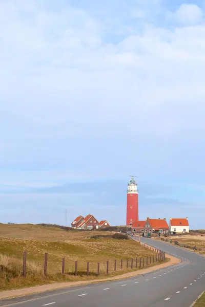 Roter Leuchtturm Mit Straße Auf Holländischer Wattenmeerinsel Texel lizenzfreie Stockfotos