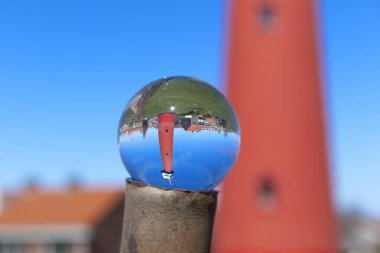 Hollanda manzarasında cam kasede kırmızı deniz feneri direğin üzerinde