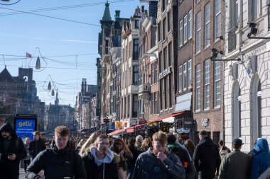 AMSTERDAM, NETHERLANDS - 24 Ekim 2021: Amsterdam, Hollanda 'da mağazaları, otelleri ve kanalları olan ünlü Damrak manzarası