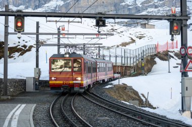 Bir çarklı tren Jungfraujoch 'tan (Avrupa' nın tepesi) Kleine Scheidegg 'e kar yamacındaki Eiger, Monch ve Jungfrau ile birlikte Bernese Highlands, İsviçre' ye gider.