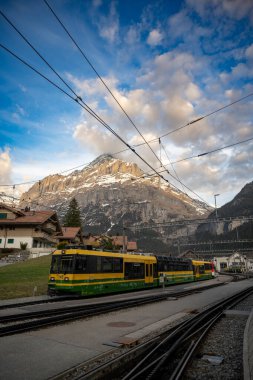 GRINDELWALD, SWitzERLAND - 13 Nisan 2022 Grindelwald tren istasyonu ve Alpler 'in etrafını sardı. İsviçre