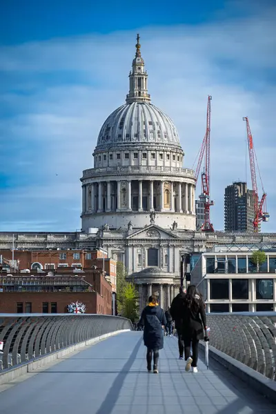 Londra, İngiltere 20 Nisan 2024: Arkaplanda Aziz Paul Katedrali ile Milenyum Köprüsü boyunca yürüyen yayalar.