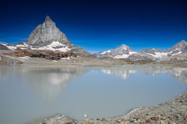 Matterhorn dağı İsviçre 'nin Zermatt şehrinde açık bir günde buzul gölüne yansıyor..