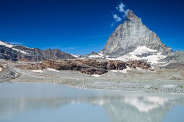 Matterhorn dağı İsviçre 'nin Zermatt şehrinde açık bir günde buzul gölüne yansıyor..