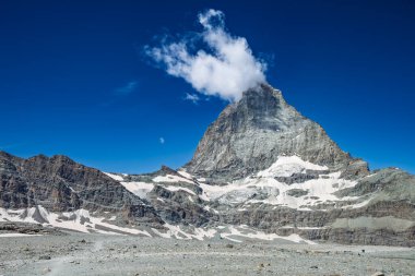 Görkemli Matterhorn dağı berrak mavi gökyüzünün altında kısmen bir bulut zerresi ile örtülü..