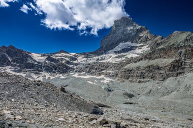 Güneşli bir günde, mavi gökyüzü ve bulutlarla Matterhorn buzulu manzarası..