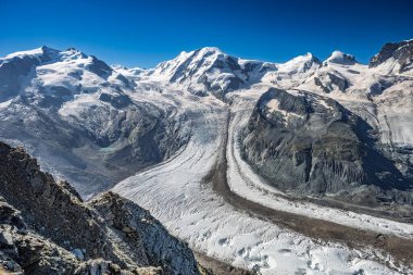 Büyük bir buzul, İsviçre Alpleri 'nin dramatik manzarasını gözler önüne seren yüksek Matterhorn zirvesinden iniyor..