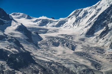 Karla kaplı engin dağlar, buzulların oluşturduğu derin bir vadiyi gözler önüne seriyor..
