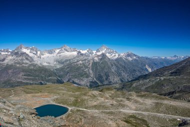 Resmedilmeye değer bir dağ manzarası karla kaplı dağlar ve dingin bir turkuaz göl..