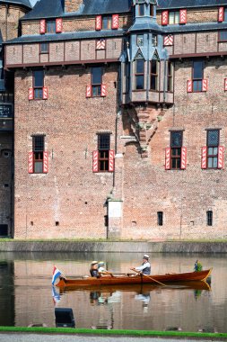 People enjoy a leisurely boat ride on the moat surrounding Kasteel de Haar.