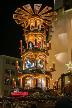 Sıcak Noel ışıkları olan güzel ışıklı bir ağaç Fransa 'daki Mulhouse Noel pazarında kırmızı ışıklı Tapınak Saint-tienne' in önünde duruyor..