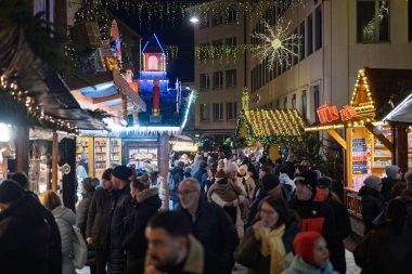 Sıcak Noel ışıkları olan güzel ışıklı bir ağaç Fransa 'daki Mulhouse Noel pazarında kırmızı ışıklı Tapınak Saint-tienne' in önünde duruyor..