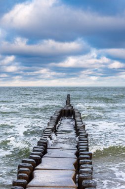 Groyne and waves on shore of the Baltic Sea in Ahrenshoop, Germany.