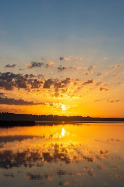 Seedorf, Almanya 'daki Schaalsee gölünde bulutlarla gün doğumu ve yansıma.