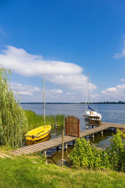 Jetty ve yelkenlileri Almanya 'nın Zarrentin şehrinde Schaalsee gölünde.