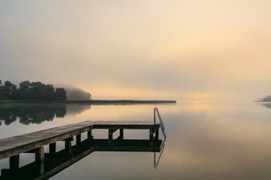 Seedorf, Almanya 'da gün doğumunda Schaalsee Gölü' nde yüzen iskele..