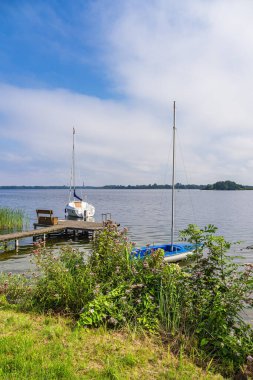 Jetty ve yelkenlileri Almanya 'nın Zarrentin şehrinde Schaalsee gölünde.