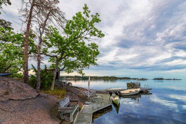 Baltic Sea coast with landing stage and boats near Oskarshamn in Sweden. clipart