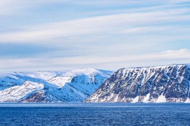 Norveç 'teki Hammerfest yakınlarında kışın dağlar, kayalar ve bulutlar.
