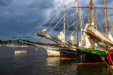 Almanya, Rostock 'taki Hanse Yelkenlisi sırasında Warnow nehrinde yelken açan gemiler..